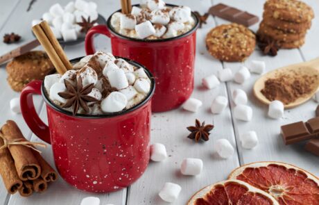 Two red mugs of Christmas hot chocolate