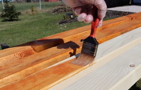 Person brushing timber with varnish