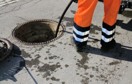 Workman pushing pipe down a drain